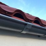 Steel guttering attached to a house wall and a roof edge